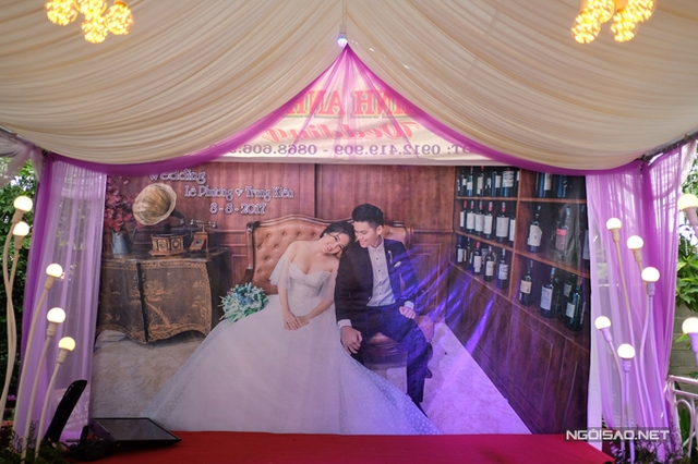 
Tấm ảnh cưới ngọt ngào của cặp đôi được treo chính giữa sân khấu nhà gái.
