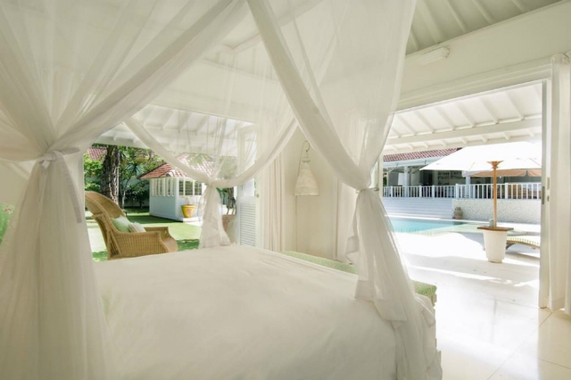 Phòng ngủ dưới tầng trệt có thể mở thông ra bể bơi và bãi cỏ xanh mát.