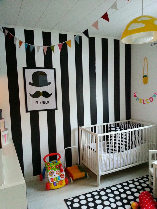 Họa tiết kẻ sọc gợi nhớ những điều xưa cũ. Bức tường đen trắng gi&uacute;p x&aacute;c định vị tr&iacute; chắc chắn của giường cũi trong ph&ograve;ng.