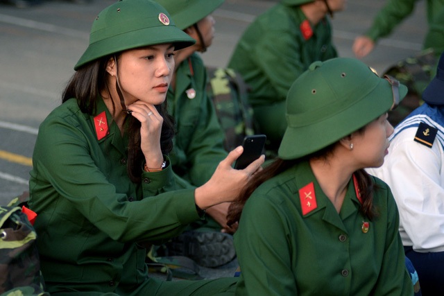 Giao Linh sửa sang áo mũ, chụp hình trong bộ trang phục lính.