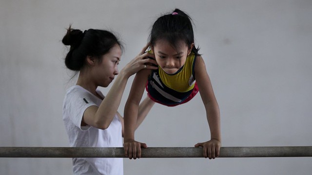 Huấn luyện vi&ecirc;n Đỗ Thị Ng&acirc;n Thương đang hướng dẫn một vận động vi&ecirc;n nh&iacute; tập m&ocirc;n x&agrave; lệch. Tại trung t&acirc;m hiện c&oacute; 3 huấn luyện vi&ecirc;n nữ v&agrave; 4 huấn luyện vi&ecirc;n nam.
