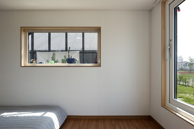 Không gian tầng hai chính là phòng ngủ của gia đình. Nội thất khá đơn giản khi chỉ có một giường đơn sắc và tông màu gỗ chủ đạo.