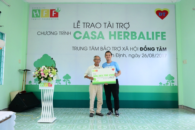 Ông Phạm Tường Huy, Tổng Giám đốc Herbalife Việt Nam (phải) trao gói tài trợ cho Trung tâm BTXH Đồng Tâm.