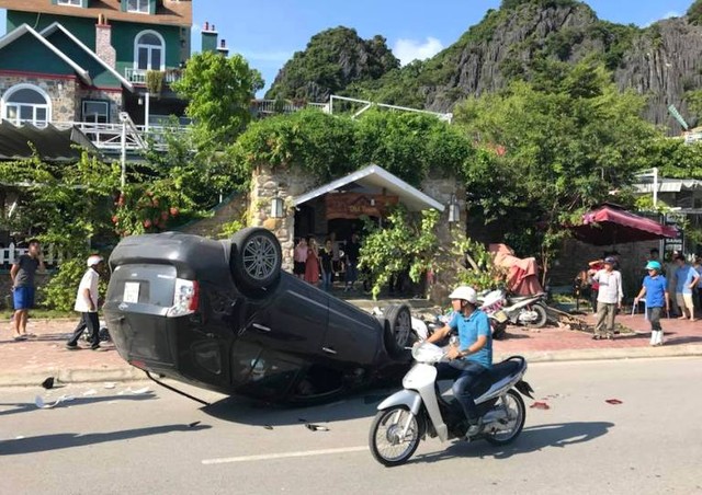 Sau khi đâm hàng loại xe máy, chiếc ô tô đâm vào cột điện và lật ngửa ra đường. Ảnh: N.Hưng