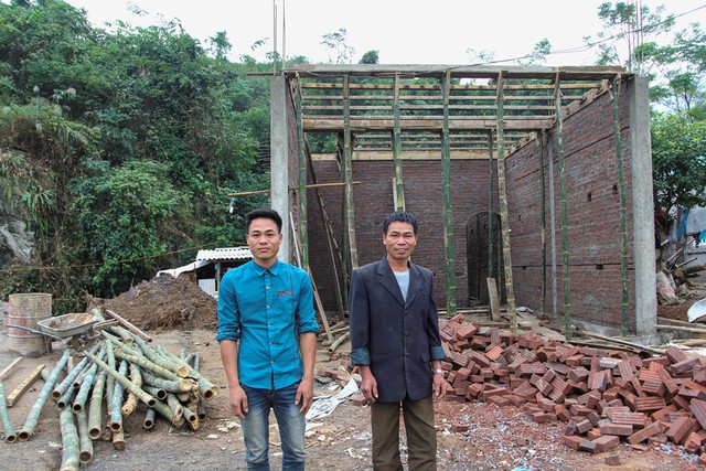 
Anh Bùi Văn Dũng và bố ruột là ông Bùi Văn Linh bên căn nhà đang xây ven quốc lộ 6.
