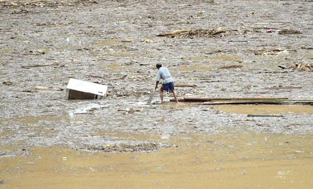 Người đàn ông này đi dọc hồ thủy điện tìm thi thể con trai mất tích sau bão lũ.