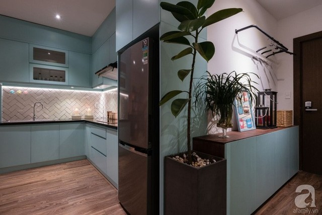 Sự liên kết nhẹ nhàng giữa màu xanh của tủ bếp với tủ đựng giày gần cửa ra vào cũng mang đến cho mọi người ghé thăm nhà cảm giác hài hòa và ấn tượng.
