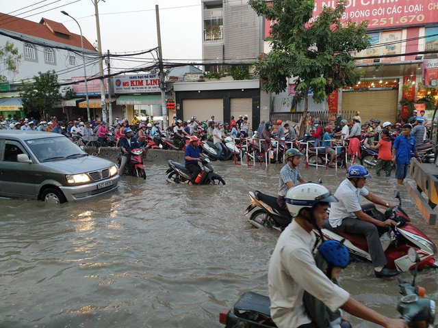 Triều cường dâng cao gây ngập đường Huỳnh Tấn Phát khiến người dân gặp nhiều khó khăn khi di chuyển qua đây