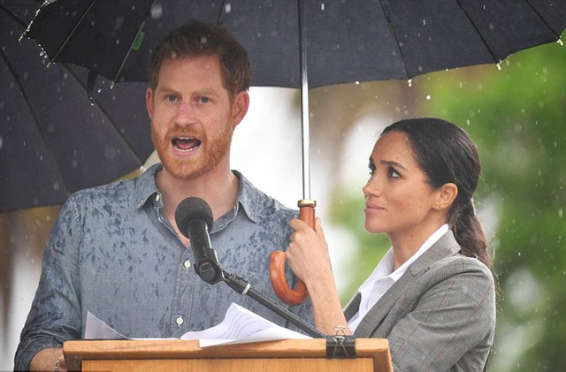 Meghan thay vệ sĩ cầm ô che mưa cho chồng khi đang phát biểu sáng 17/10 ở Dubbo, bang New South Wales. Ảnh: REX.