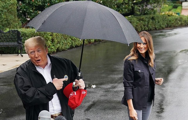 Ông Trump che ô một mình, để vợ đầu trần ngoài mưa (Ảnh: AFP)