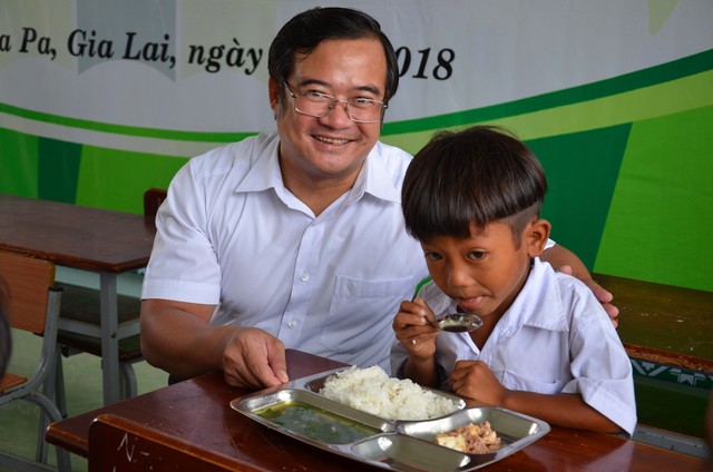 Ông Võ Anh Tuấn Bí thư huyện ủy Ia Pa với một học trò lần đầu tiên được dùng “Cơm Có Thịt” tại trường.