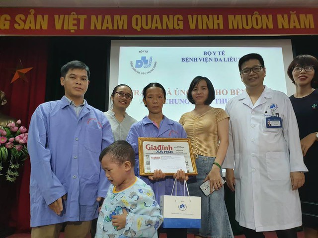 
PV Phương Thuận - đại diện Báo Gia đình và Xã hội (áo vàng) - cùng lãnh đạo Bệnh viện Da liễu TƯ và nhà hảo tâm trao tiền cho gia đình bé Thuyên trong ngày xuất viện
