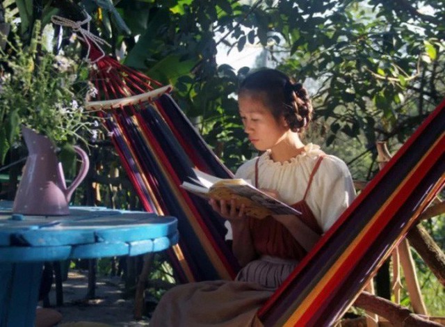 
Cô gái đọc sách bên vườn nhà.
