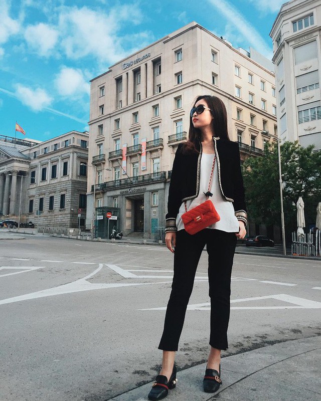 Trong chuyến đi châu Âu, Đỗ Mỹ Linh sắm thêm một chiếc túi Chanel màu đỏ cam cho mình. Kết hợp cùng túi hiệu đắt tiền, nàng Hậu chọn mặc cùng áo khoác lửng thanh lửng, mix với quần đen ton-sur-ton và áo phông trắng.