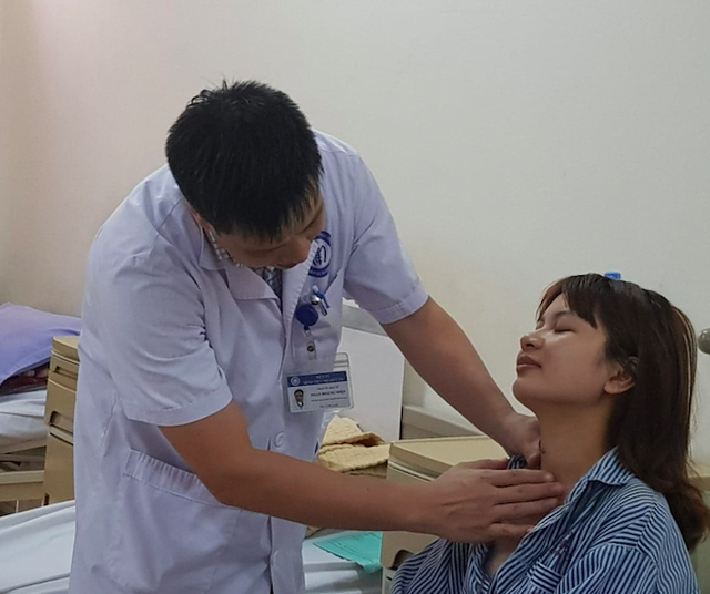 
BS Phan Hoàng Hiệp khám cho bệnh nhân Vương Thị Thu - một trong 20 bệnh nhân đầu tiên được phẫu thuật nội soi tuyến giáp một lỗ
