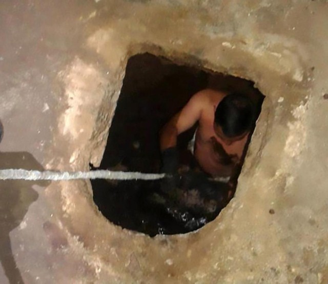 Nh&acirc;n vi&ecirc;n cứu hộ d&ograve; t&igrave;m b&eacute; g&aacute;i sơ sinh dưới bể phốt ở l&agrave;ng Rio de la Virgen, Jutiapa, miền nam Guatemala. Ảnh: Central European News.