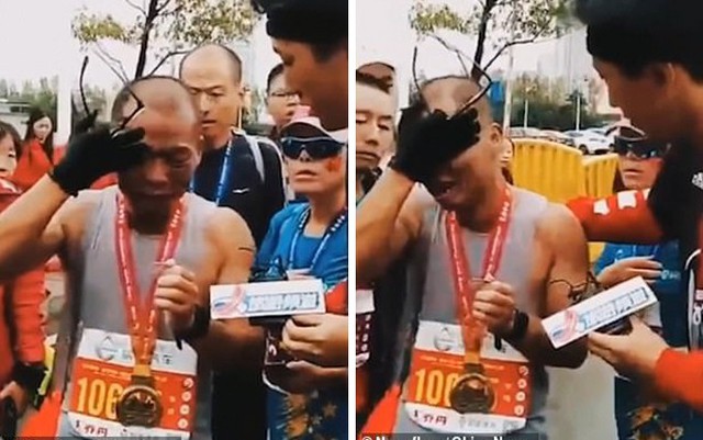 Anh Li Gang bật khóc khi về đích giải chạy 42 km Nanchang International Marathon hôm 11/11 tại thành phố Nam Xương, Trung Quốc. Trên tay anh khi đó là tấm ảnh con trai đã mất. Ảnh: China News.