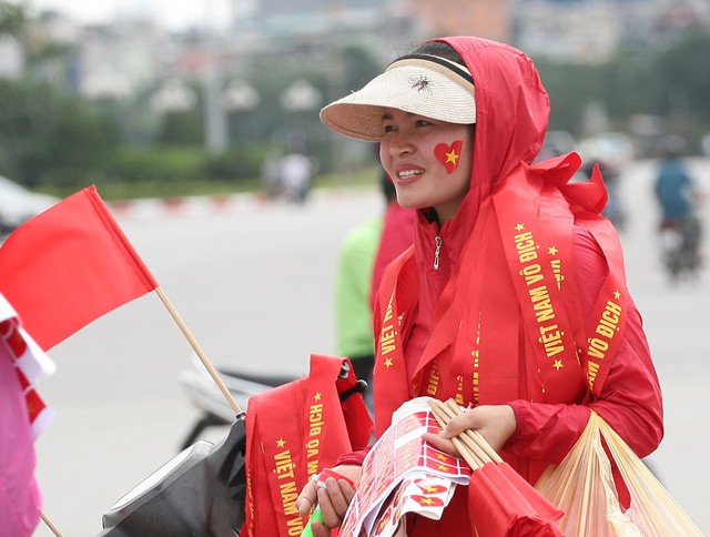 
Một người phụ nữ cho biết, những ngày bình thường bán trà đá ở Đình Thôn nhưng nay ra bán cờ, băng-rôn.
