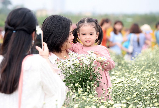 
Dù tiết trời Hà Nội ngày cuối tuần khá nắng nhưng cũng không quản bước chân của những người yêu loài hoa này, trong số đó nhiều bà mẹ trẻ đã không cưỡng lại được vẻ đẹp nên đã cho con em mình đến những vườn cúc.
