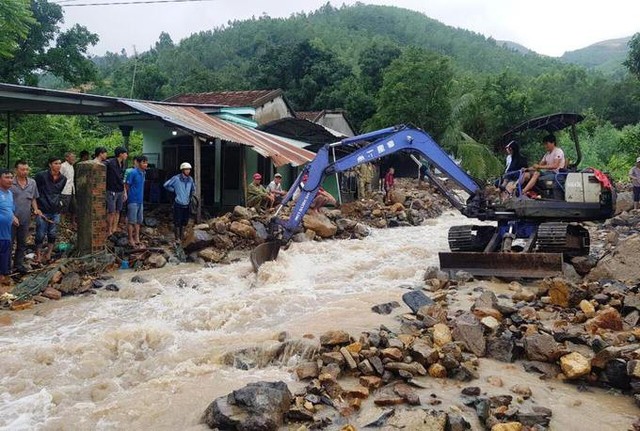 Ở xã Phước Đồng, TP Nha Trang, nơi chịu thiệt hại nặng nhất trong lận lũ quét sau bão số 8 hồi tuần trước, người dân dùng máy xúc để khơi dòng cho nước chảy, tránh việc dòng nước cuốn đất đá xuống phía dưới.