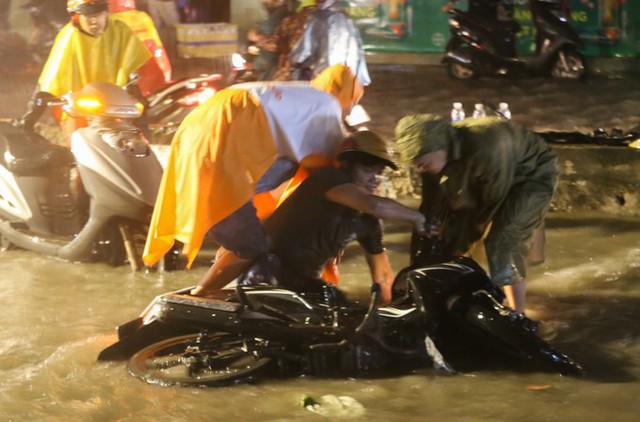 Nhiều người chạy xe máy vấp vào ổ gà trên đường Huỳnh Tấn Phát, ngã nhào trong cơn mưa nặng hạt. Ảnh: VnExpress.