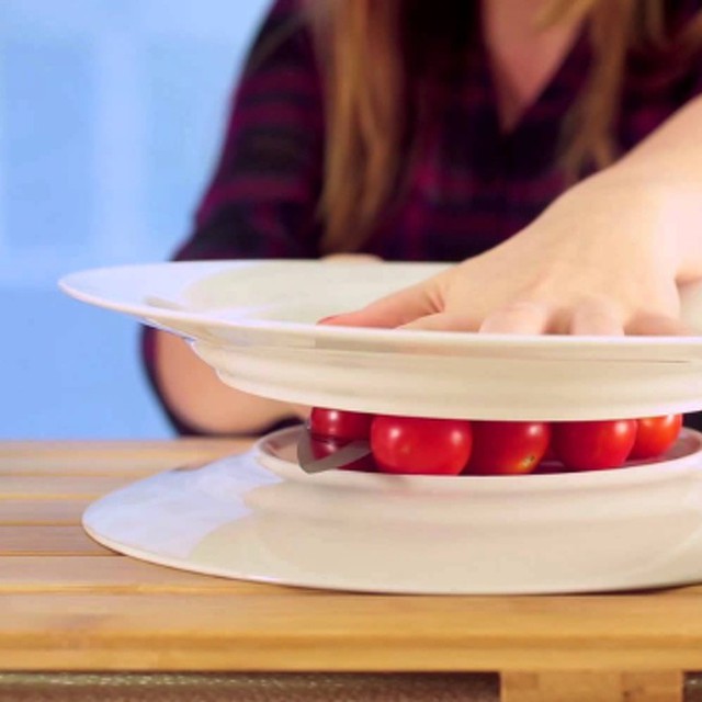 5. Cắt đôi cà chua bi: Bạn cần cắt cà chua bi cho món salad, hãy sử dụng 2 chiếc đĩa kẹp cà chua bi vào giữa, sau đó dùng dao cắt đôi chúng theo một đường thẳng.