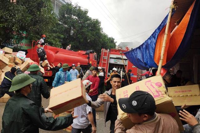 
Hàng trăm người dân khẩn trương di chuyển hàng hóa ra khu vực an toàn.
