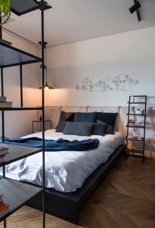 
Một chiếc giường lớn với đầu giường bọc nệm thoải mái, bàn cạnh giường làm bằng gỗ kết hợp kim loại tạo cái nhìn cho căn hộ hiện đại.
