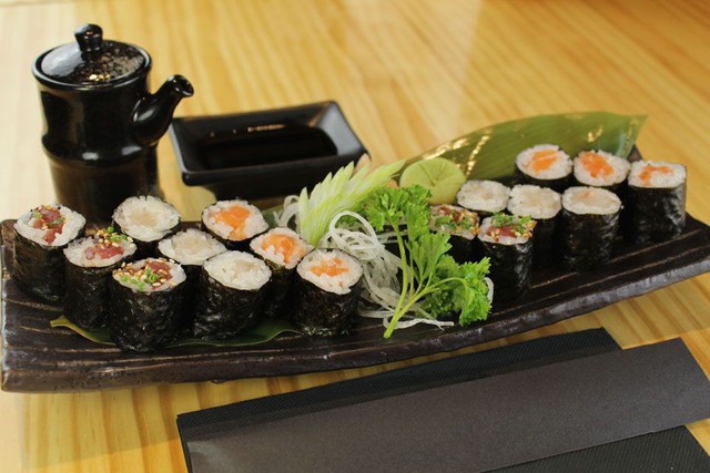 Có cách nhất định để cắt sushi cuộn makimono: Bạn có tự hỏi rằng l àm thế nào để những cuộn sushi được cắt ra hoàn hảo? Các đầu bếp sushi tiết lộ rằng có một cách nhất định để điều khiển con dao, biến ước muốn đó thành hiện thực.  Khi cắt makimono, người ta sẽ bắt đầu với phần gót dao (góc cuối lưỡi dao) ở một góc 45 độ, sau đó sử dụng toàn bộ lưỡi dao, thực hiện chuyển động quét qua nửa cuộn sushi. Cuối cùng, hoàn thành việc cắt sushi bằng cách cân bằng lưỡi dao song song với thớt và cắt về phía trước. Bạn đừng tạo áp lực lên dao vì sẽ làm dẹt makimono. Ảnh: Tokyo Sushi.