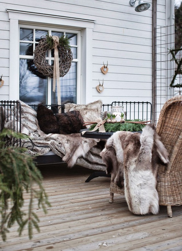
3. Góc thư giãn mùa đông ấm cúng với ghế dài bằng kim loại, ghế đan bằng liễu gai, gối lông vũ và đèn lồng nến.

