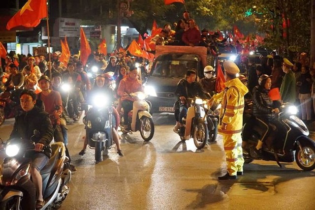 
CĐV tràn xuống đường ăn mừng khu vực Kim Mã - Nguyễn Thái Học (Hà Nôi). Cảnh sát phải dựng rào chắn ngăn chặn phương tiện vào phố cấm, phân luồng phương tiện.
