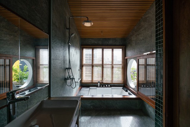 Phòng tắm được thiết kế mang phong cách tối giản và có cửa sổ tròn hướng mở về thiên nhiên.