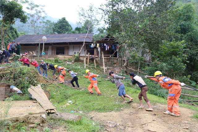 
Bà con dân tộc Thôn Đá Đen cùng CBVN Điện lực Văn Chấn kéo dây để đưa điện về thôn
