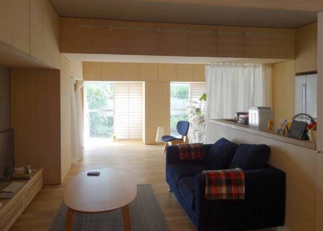 
Không gian tiếp khách được bố trí đơn giản với bàn trà gỗ và sofa màu tối thanh lịch, cá tính.
