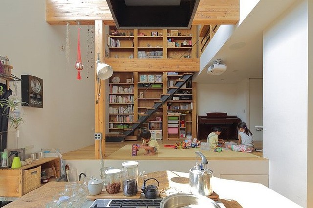 Trong một bối cảnh ta có thể quan sát thấy một nhà bếp tiếp nối từ phòng khách. Trực quan phòng khách cho ta thấy, chất liệu gỗ chiếm đa phần không gian, với những khối trụ to, và từ kệ đựng sách.