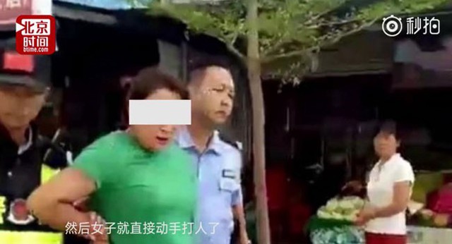 Cảnh s&aacute;t bắt người phụ nữ, giải đi sau vụ việc.