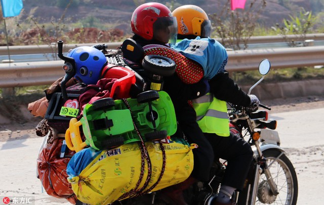 Một cặp vợ chồng chở xe &ocirc;t&ocirc; đồ chơi để tặng cho những đứa con ở qu&ecirc;.