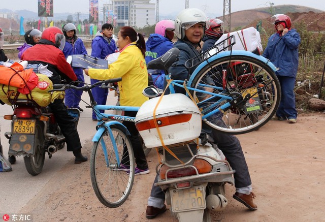 Người đ&agrave;n &ocirc;ng n&agrave;y c&ograve;n chở một chiếc xe đạp cồng kềnh ph&iacute;a sau xe.