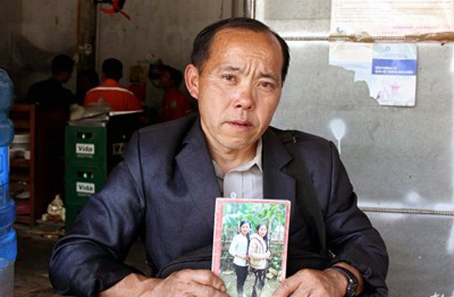 Ông Ga đưa tấm ảnh hai con gái đến trình báo tại CA huyện Quế Phong (Ảnh: Hùng Cường)
