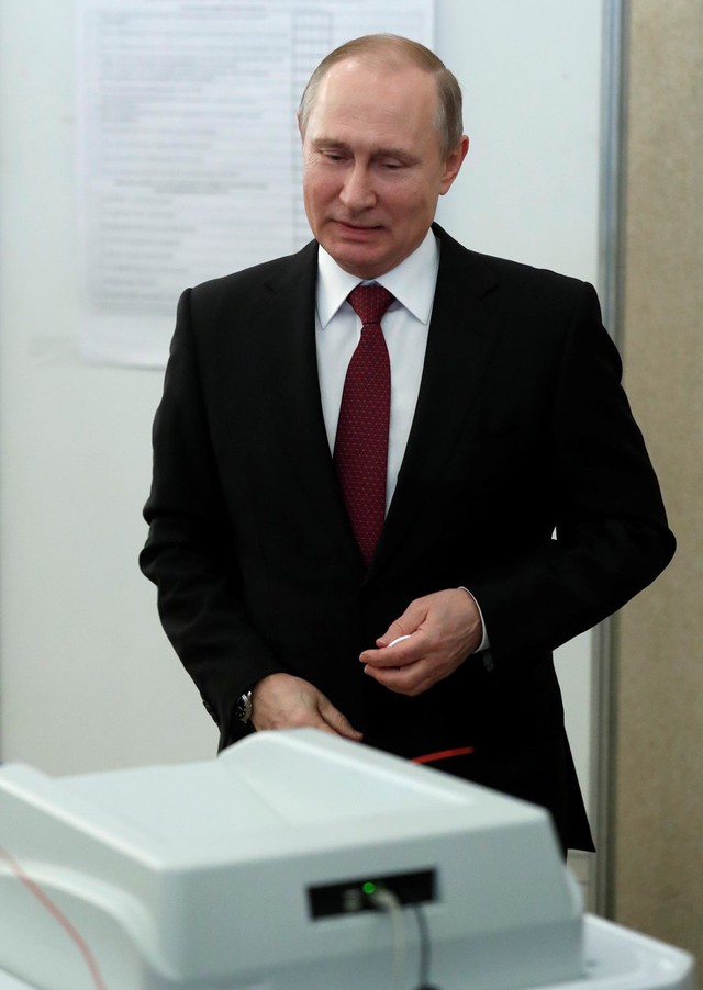 Đương kim tổng thống, ứng viên tổng thống Putin tươi cười sau khi bỏ lá phiếu của ông tại địa điểm bầu cử. Ảnh: Reuters