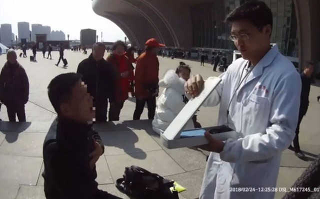 Nhân viên y tế thực hiện sơ cứu và cho Li uống thuốc ngay trước cửa nhà ga.
