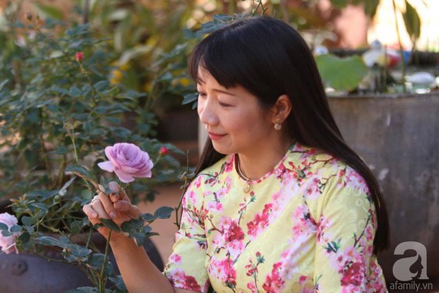 Chị Hồng Hạnh dịu dàng bên đóa hồng trước sân nhà.
