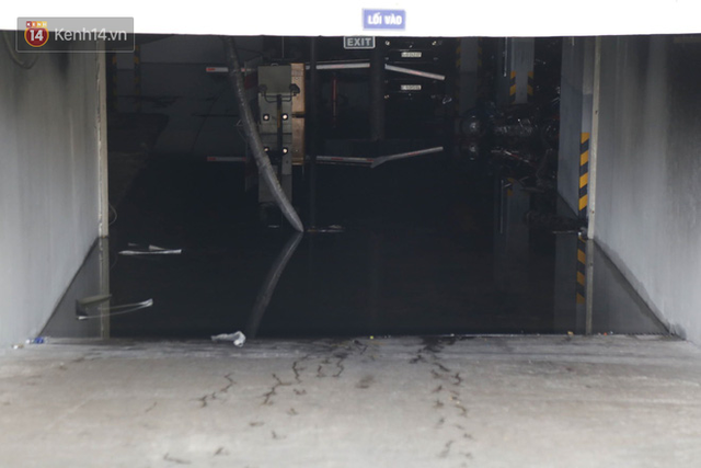 Hầm để xe nơi bùng phát vụ cháy giờ ngập trong nước - Ảnh: Tứ Quý