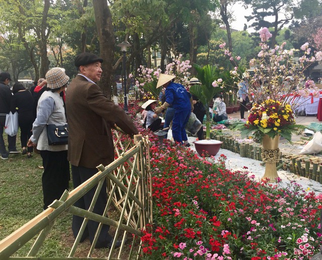
Một cặp vợ chồng lớn tuổi ngắm nhìn hoa anh đào qua hàng rào ban tổ chức thiết lập để ngăn du khách tiến vào trong.
