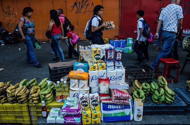 Người dân phải tới các chợ đen ở ngoại ô thủ đô Caracas để mua các nhu yếu phẩm khó tìm như xà phòng, dầu gội đầu, bột ngô hay gạo. Ảnh: New York Times.