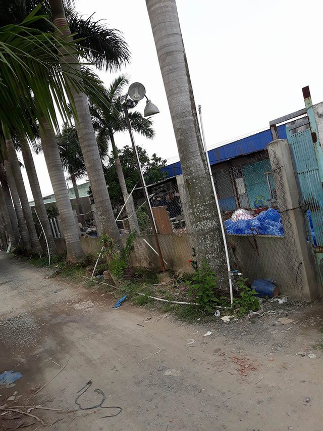 Bên trong tường ngổn ngang rác lẫn với hàng chục bình nhựa rỗng màu xanh lại 18l
