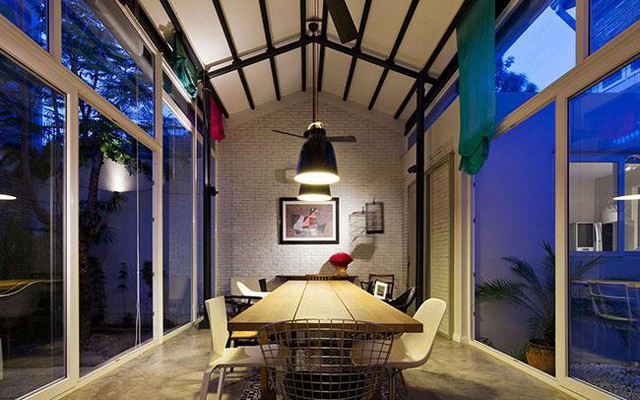 Phòng ăn với 2 bức tường phụ đều bằng kính là không gian trung tâm trong toàn bộ căn nhà. Căn phòng này nằm giữa hai sân trong và giữa hai gian nhà bếp và phòng khách.
