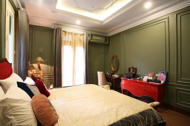Sàn các phòng ngủ đều được lát gỗ để tăng sự ấm áp. Chiếc bàn đỏ là thiết kế đầy dụng ý, tạo điểm nhấn cho phòng ngủ.