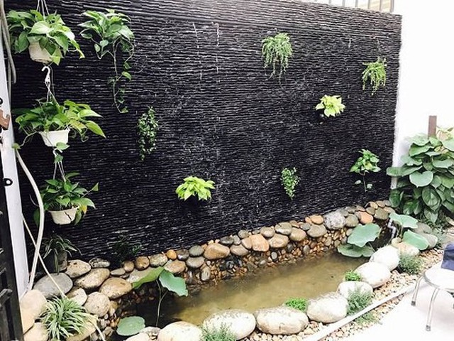 Bức tường đá với nước chảy róc rách, cây được trồng xen kẽ tạo điểm nhấn dịu dàng, nên thơ.
