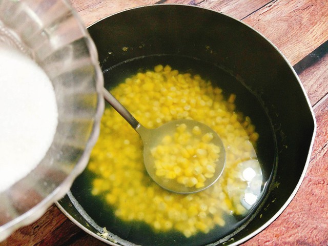 Cho hỗn hợp đường và bột rau câu vào cùng, vừa cho vừa khuấy đều để rau câu không bị vón cục. Tiếp tục nấu cho nồi rau câu bắp sôi lên khoảng 2 phút nữa là tắt bếp.